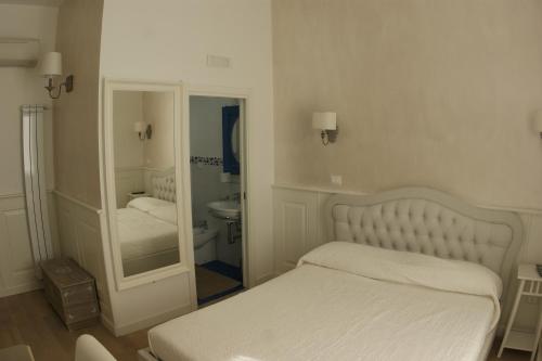 ein weißes Schlafzimmer mit einem Bett und einem Spiegel in der Unterkunft Alba Sul Vaticano in Rom