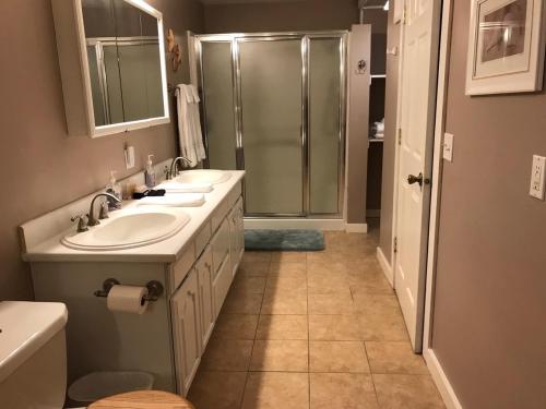 a bathroom with two sinks and a shower at Inn at Harbour Village in Ilwaco