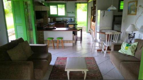 a living room with a couch and a table at Casa do Eduardo in Praia do Rosa