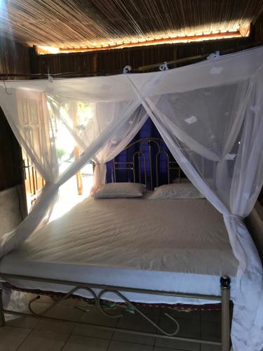 a bed with a canopy in a room at Ova Baluk Bungalow in Nembrala