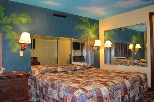 Habitación de hotel con cama y espejo grande en Economy Inn New Orleans en Nueva Orleans
