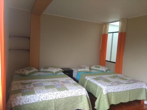 a room with two beds and a window at Gran Hotel Virrey in San Ramón
