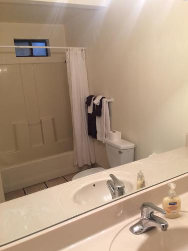 a bathroom with a sink and a toilet and a mirror at Stagecoach Suites in Wickenburg