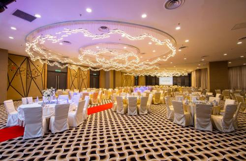 a large banquet hall with white tables and chairs at Fraser Place Puteri Harbour in Nusajaya