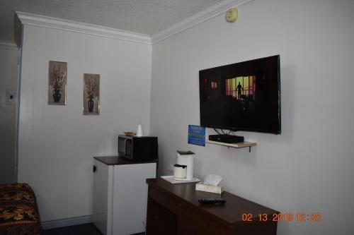 a living room with a television on a wall at Evening Star Motel in Greenwood