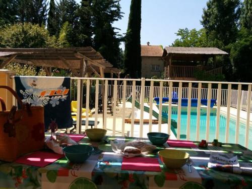 - une table avec des bols à côté d'une piscine dans l'établissement Villa du Lez, à Prades-le-Lez