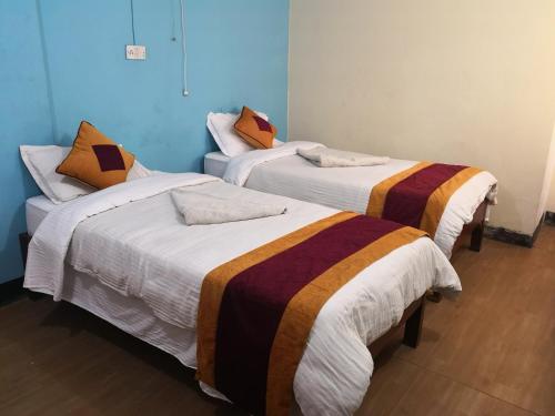 3 łóżka w pokoju z niebieskimi ścianami w obiekcie Holyland Guest House w Katmandu