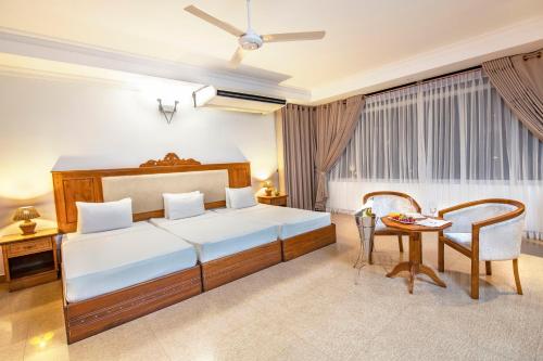 a hotel room with a bed and a table at Hotel Sudu Araliya in Polonnaruwa