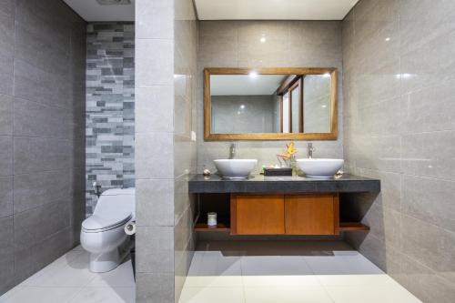 Un baño con dos lavabos y un espejo. en Surya Mas Villa, en Legian