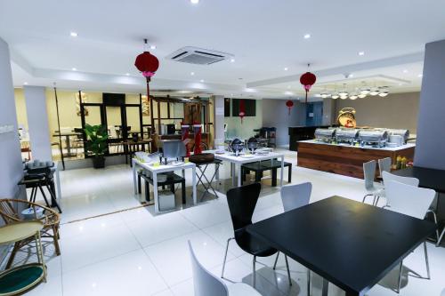 a restaurant with tables and chairs and a counter at Hotel 99 Kuala Lumpur City in Kuala Lumpur