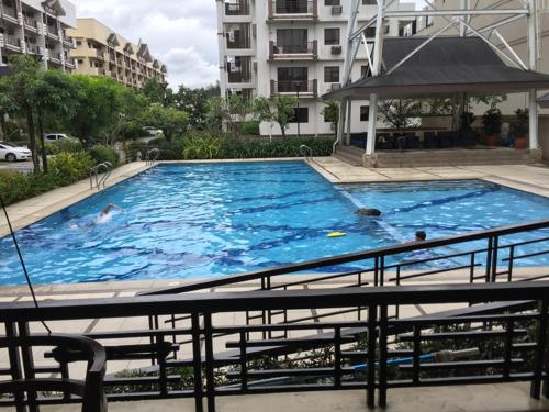 a large swimming pool with people swimming in it at Spacious Condo Unit - The Redwoods Novaliches, QC, Philippines in Manila