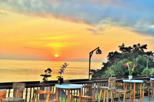 a restaurant with tables and chairs overlooking the ocean at Ocean Terrace Suite And Spa Luxury in Nusa Penida