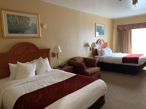 a hotel room with two beds and a chair at SureStay Plus Hotel by Best Western Mesquite in Mesquite