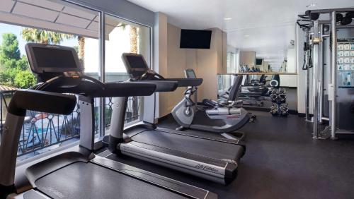 a gym with treadmills and ellipticals in a room at Hyatt Regency Valencia in Valencia