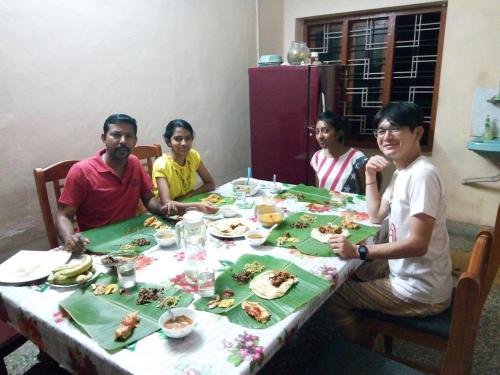 a group of people sitting at a table eating food at Spice Garden Farm house in Sultan Bathery