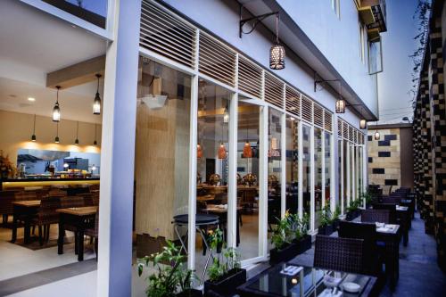 a restaurant with tables and chairs in front of a building at H Boutique Hotel Jogjakarta in Yogyakarta