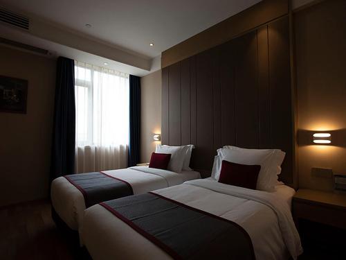 a hotel room with two beds and a window at SHANGHAI-DECO Hotel-Free shuttle bus to Pudong Airport and Disneyland in Shanghai