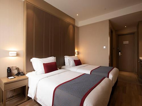 two beds in a hotel room with two beds sidx sidx sidx at SHANGHAI-DECO Hotel-Free shuttle bus to Pudong Airport and Disneyland in Shanghai