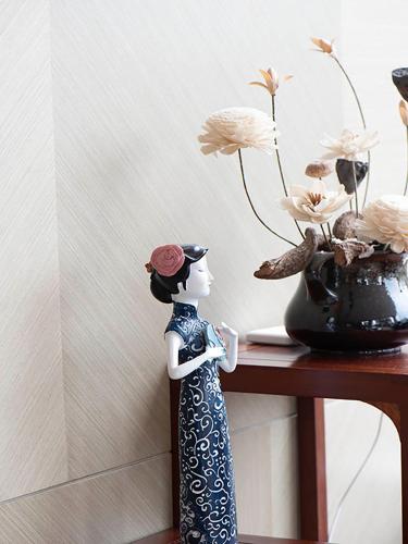 a doll sitting on a table next to a vase with flowers at SHANGHAI-DECO Hotel-Free shuttle bus to Pudong Airport and Disneyland in Shanghai
