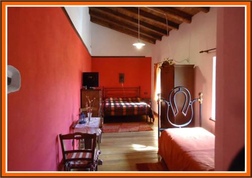 sypialnia z czerwonymi ścianami oraz łóżkiem i stołem w obiekcie Crete Gialle w mieście Cassino