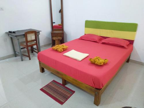 a bedroom with a large bed with a red blanket at Selahn Inn in Katunayake