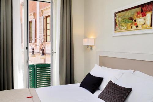 una camera da letto con un letto bianco e una finestra di Piazza Venezia Grand Suite a Roma