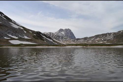 a body of water in front of a mountain at Il Narciso appartamenti in Assergi