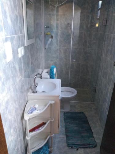 y baño con lavabo, aseo y ducha. en Casa Maringá, en Visconde De Maua