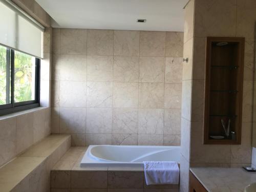 y baño con bañera y ventana. en Villas at Da Nang Beach Resort,3 Bedrooms Garden View, en Da Nang