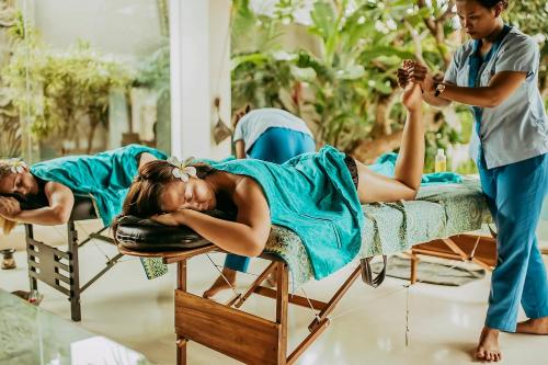 a group of people laying on beds in a room at Chandra Bali Villas in Seminyak