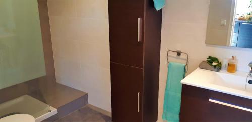 a bathroom with a sink and a toilet and a mirror at Ashram Villa Sunshine in Sitges