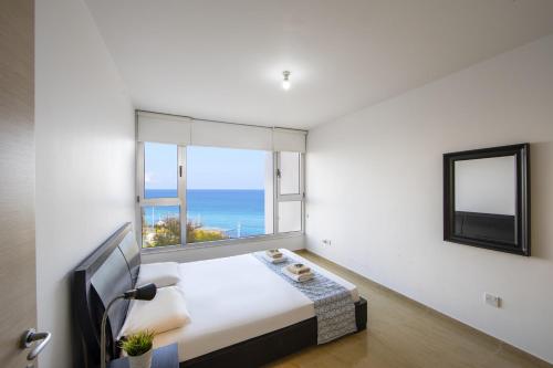 プロタラスにあるone bedroom apartment in Fig tree bayのベッドと大きな窓のある寝室