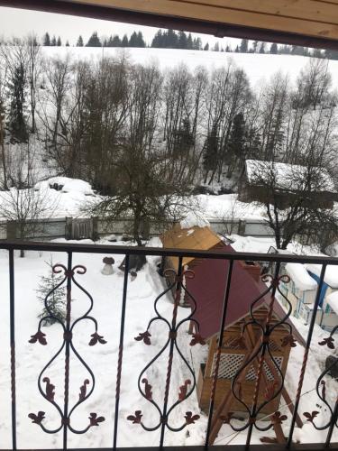 a view of a snow covered yard from a balcony at Sadyba Domashniy zatyshok in Pilipets