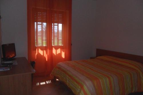 a bedroom with a bed and an orange door at Country House L'Ippocastano in Altavilla Silentina