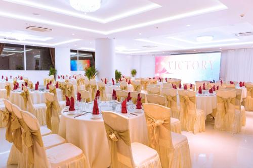 a banquet hall with white tables and chairs at Victory Hotel Tây Ninh in Tây Ninh
