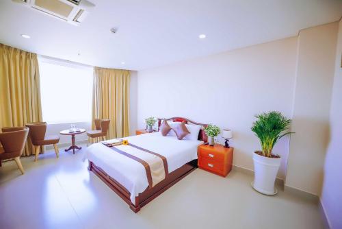 a hotel room with a bed and a table and chairs at Victory Hotel Tây Ninh in Tây Ninh