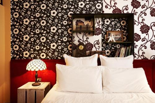 a bedroom with a bed with a black and white wallpaper at Hour Roots in Tainan