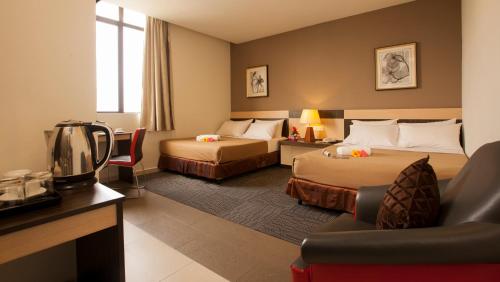 Habitación de hotel con 2 camas y sofá en LEO Express Hotel en Kuala Lumpur