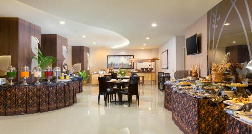 un restaurante con mesas y sillas con comida. en Best Western Papilio Hotel en Surabaya