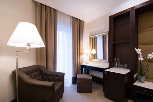 um quarto de hotel com uma cadeira, uma secretária e um espelho em Rixos-Prykarpattya Resort em Truskavets