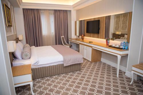 a hotel room with a bed and a desk at Theatrum Hotel Baku in Baku