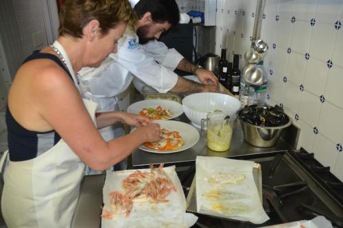 two chefs preparing food in a kitchen at La Sosta di Ottone III in Levanto