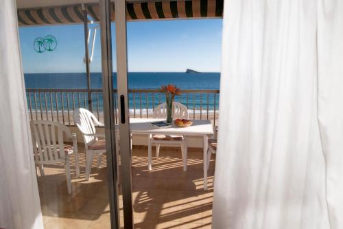 a table and chairs on a balcony with the ocean at Apartamentos María Cristina Beach in Benidorm
