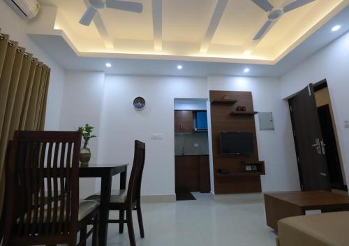 a living room with a table and chairs and a television at Swades Myhome in Trivandrum