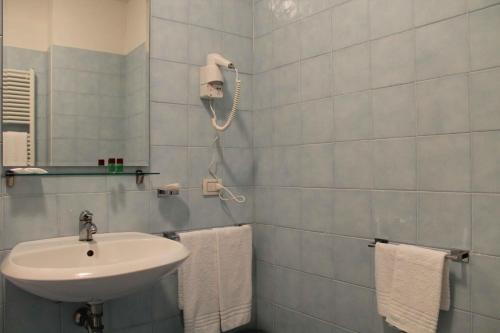 y baño con lavabo, espejo y toallas. en Hotel Cremona Viale, en Cremona
