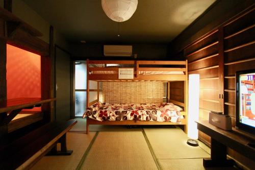 a bedroom with a bunk bed and a tv at Kyoto Traditional Machiya House in Kyoto