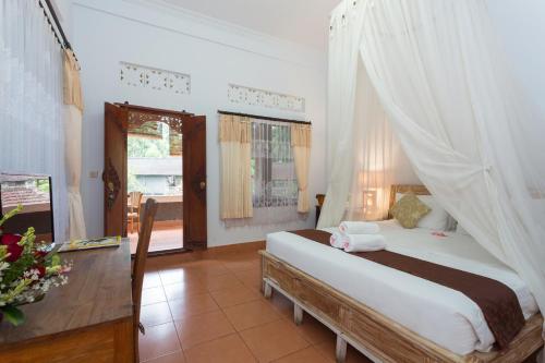 a bedroom with a bed with a mosquito net at Ani's Villas in Ubud