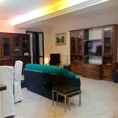 a living room with a green couch and wooden cabinets at La Residenza dei Papi in Papigno