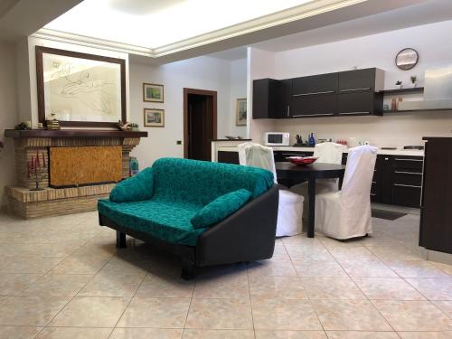 a living room with a chair and a table and a kitchen at La Residenza dei Papi in Papigno