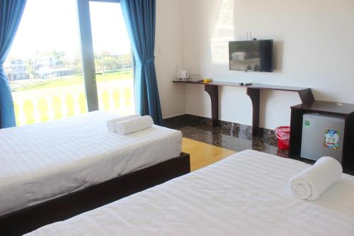 會安的住宿－Hoang Y Homestay，酒店客房设有两张床和电视。